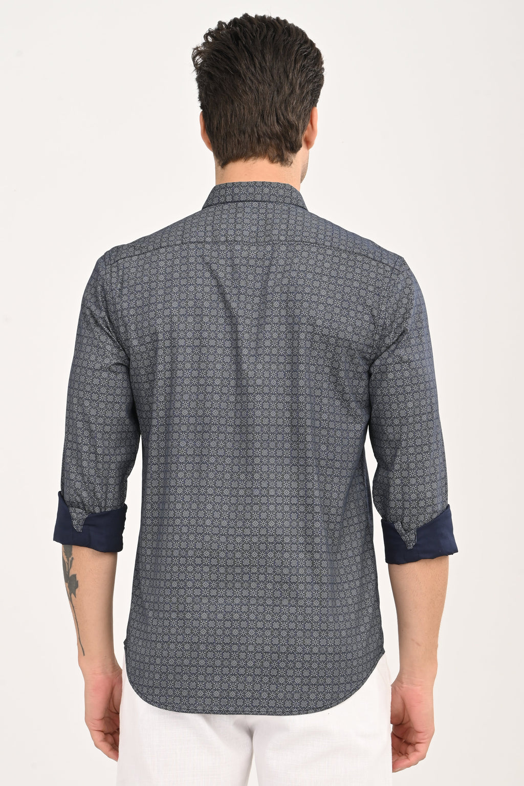 Man wearing a patterned shirt with rolled-up sleeves