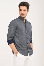 Man wearing a patterned shirt with rolled-up sleeves