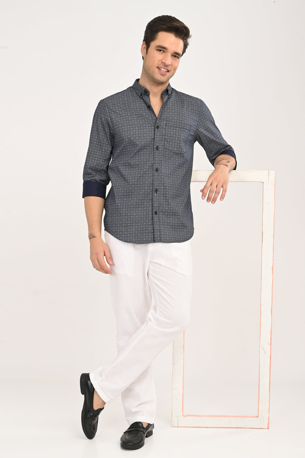 Man wearing a patterned shirt with rolled-up sleeves
