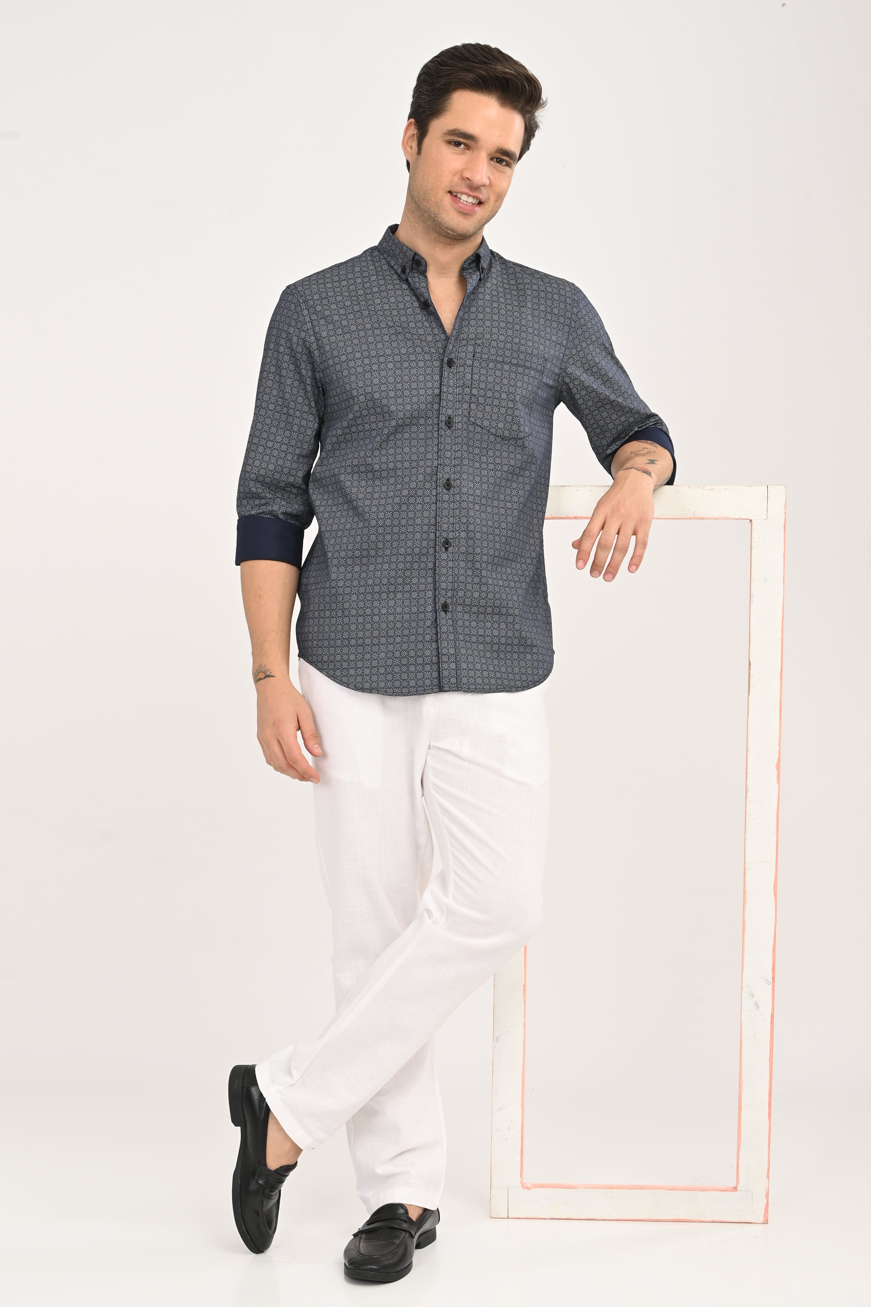 Man wearing a patterned shirt with rolled-up sleeves